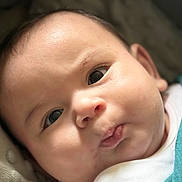 Huraira is registered to the contest to win money with this photo: baby, infant, face, eyes, skin, mouth, expression, blanket, closeup, child, cute, pout, cheeks, lying_down, soft_light, indoors, newborn, person, clothing, head