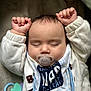 Huraira is registered to the contest to win money with this photo: baby, sleeping, pacifier, bib, arms_up, clothing, infant, soft_surface, toy, closeup, cute, peaceful, child, indoors, portrait, head, face, small_hands, resting, napping