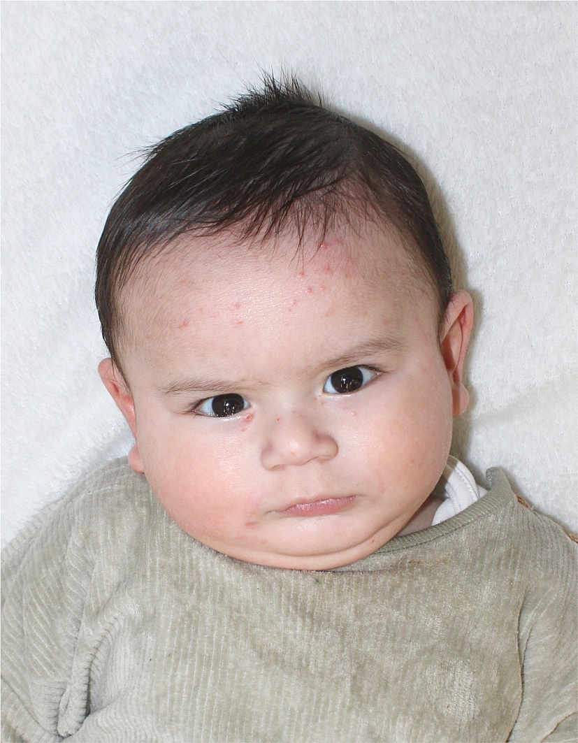 Huraira joined the competition — help win amazing prizes! baby, beige, chubby_cheeks, closeup, clothing, expression, eyes, face, furrowed_brow, hair, head, indoors, infant, lying_down, person, portrait, serious, skin, soft_texture, white_background