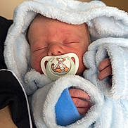 Mateo is registered to the contest to win money with this photo: newborn, baby, pacifier, blanket, blue, sleeping, infant, soft, cute, wrapped, hand, tiger, cartoon, comfort, cozy, face, child, person, rest, indoors