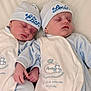 newborn, twins, baby, sleeping, infant, hat, matching_clothes, blue, white, cute, peaceful, hand_holding, soft_fabric, bed, portrait, face, child, indoors, people, rest