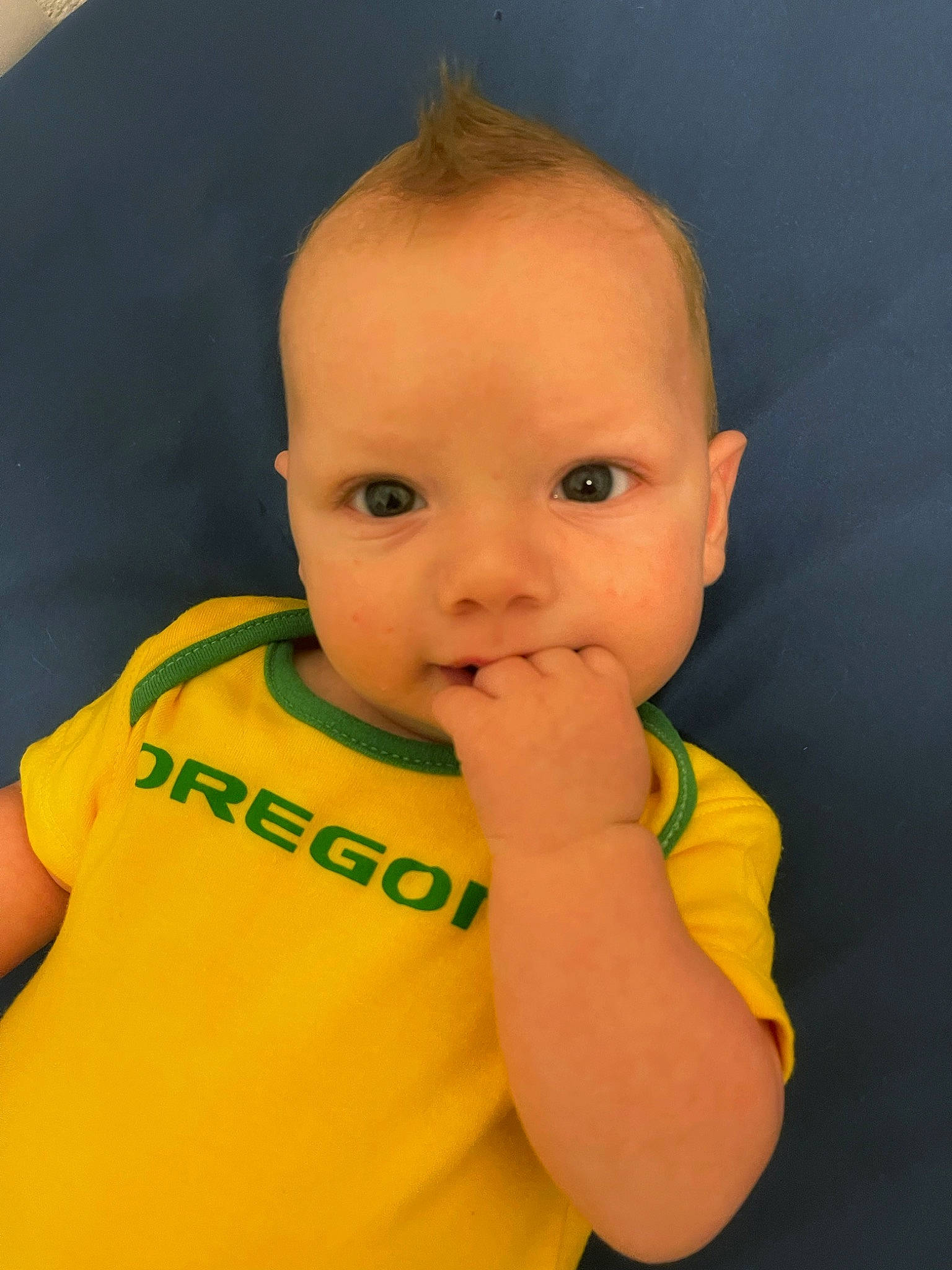 Killian is registered to the contest to win money with this photo: baby, baby_toddler_clothing, cheek, child, ear, elbow, eye, eyebrow, eyelash, finger, forehead, gesture, happy, human_body, iris, nose, person, sleeve, t_shirt, thumb
