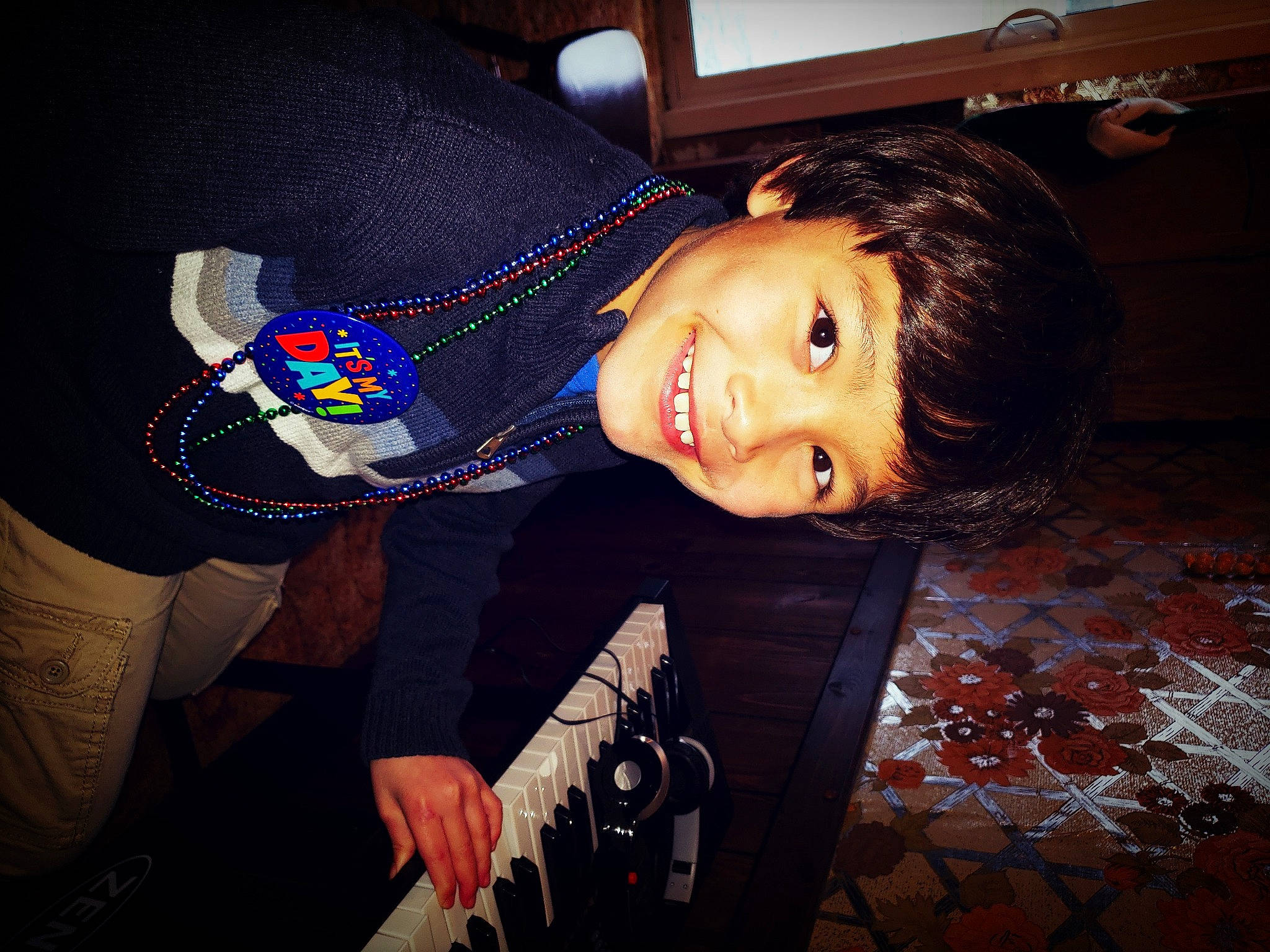 Damien is registered to the contest to win money with this photo: black_hair, child, cool, elbow, electric_blue, fashion_accessory, flash_photography, flooring, formal_wear, fun, happy, joy, person, portrait_photography, room, sitting, sleeve, smile, street_fashion