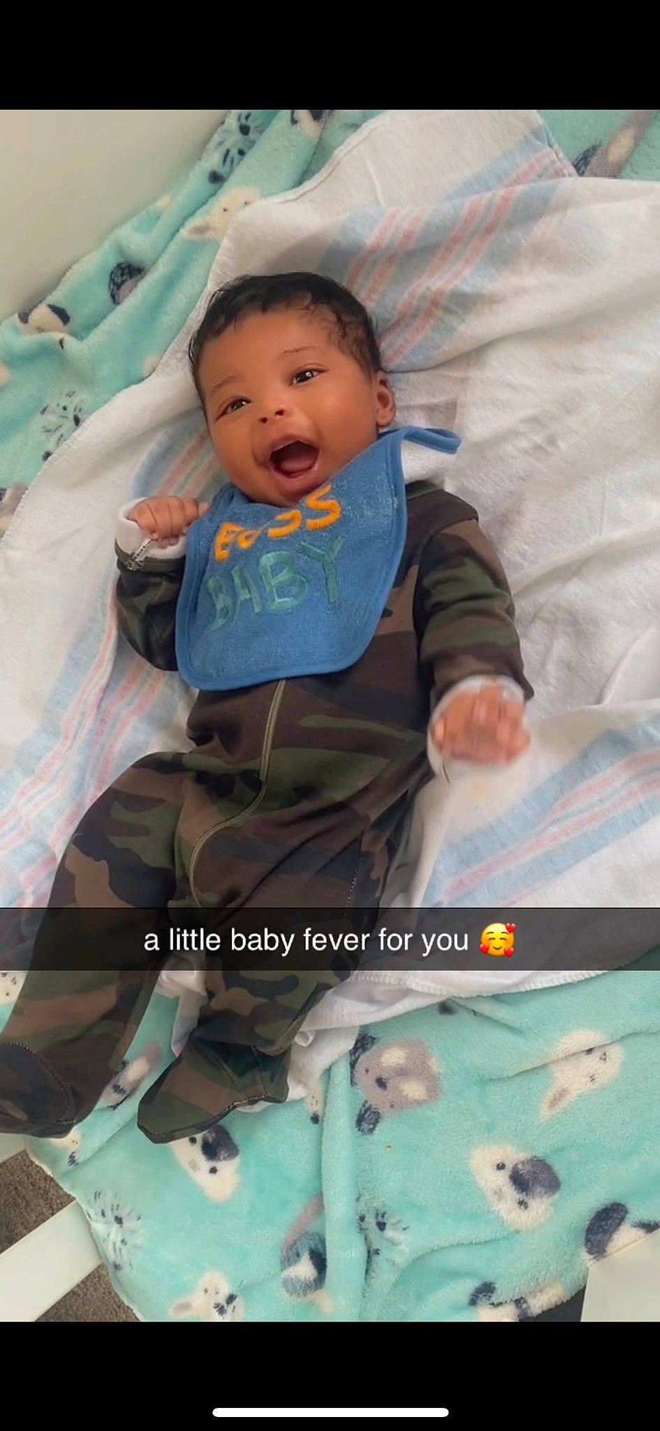 Drue is registered to the contest to win money with this photo: baby, baby_products, baby_toddler_clothing, child, comfort, face, green, happy, head, linens, pattern, person, photograph, product, room, sitting, sleeve, t_shirt, textile, toddler