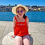 Mélina a rejoint le concours — aidez-le/la à gagner de superbes lots ! child, girl, hat, sunglasses, orange_top, shorts, waterfront, river, cityscape, sunny_day, stone_structure, reflection, blue_sky, outdoor, summer, casual_clothing, seated, smiling, tourist, holiday