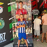 Kaïs a rejoint le concours — aidez-le/la à gagner de superbes lots ! child, boy, glasses, soccer_jersey, sports_shoes, display_case, trophy, soccer_memorabilia, life_sized_figure, cristiano_ronaldo, museum, sports_fan, indoor, people, marble_floor, reflection, tourists, casual_clothing, exhibit, portrait