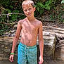 Kaïs participe au concours pour gagner de l'argent avec cette photo : boy, child, water, swim_trunks, forest, nature, sunlight, shadow, outdoor, standing, green_wristband, summer, tree, leaves, stream, rocks, casual, portrait, bare_chest, young