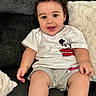 Enzo joined the competition — help win amazing prizes! baby, child, infant, smiling, happy, sitting, portrait, indoors, couch, sofa, pillow, blanket, mickey_mouse, disney, white_shirt, gray_shorts, curly_hair, brown_eyes, cozy, photography