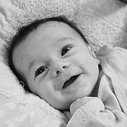 Léo a rejoint le concours — aidez-le/la à gagner de superbes lots ! baby, smile, face, eyes, infant, blanket, clothing, closeup, portrait, newborn, cute, happy, lying_down, soft_texture, monochrome, child, skin, head, hand, cozy