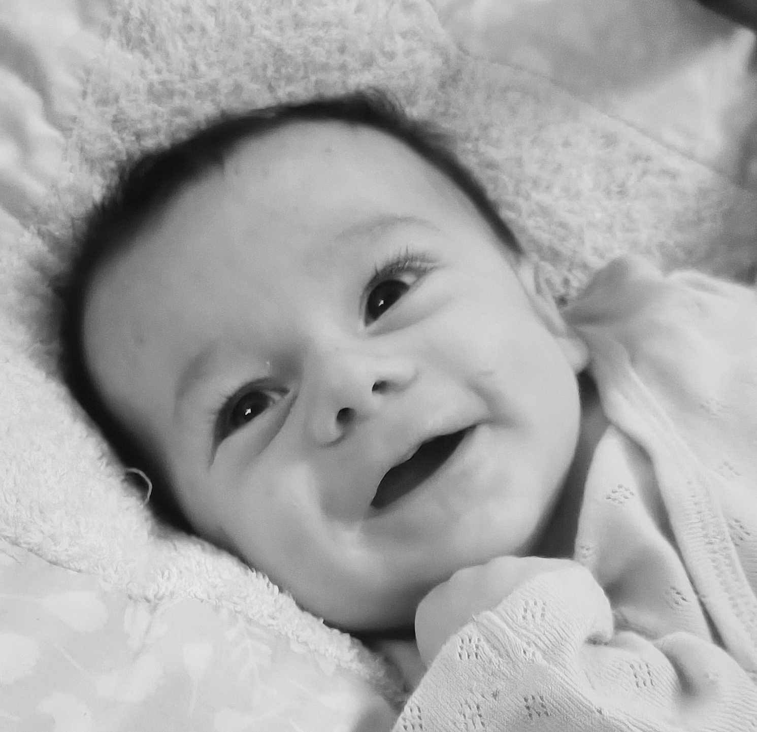 Léo a rejoint le concours — aidez-le/la à gagner de superbes lots ! baby, smile, face, eyes, infant, blanket, clothing, closeup, portrait, newborn, cute, happy, lying_down, soft_texture, monochrome, child, skin, head, hand, cozy