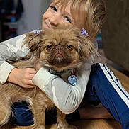 Rosie joined the competition — help win amazing prizes! blue_pants, bow, casual_clothing, child, cute, dog, domestic_animal, floor, fluffy_dog, friendship, happy, home, hugging, indoor, light_blur, pet, portrait, smiling, wooden_floor, young