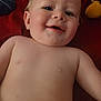 Knox joined the competition — help win amazing prizes! baby, smiling, face, skin, blanket, toy, plush, cheeks, child, lying_down, cute, happy, indoors, closeup, infant, head, expression, soft_toys, red_background, person