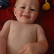 Knox joined the competition — help win amazing prizes! baby, child, smiling, bare_chest, pointing, plush_toy, red_blanket, lying_down, infant, cute, happy, skin, hand, face, portrait, indoors, young_child, expression, soft_toy, comfort