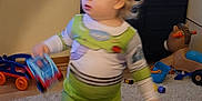 Knox joined the competition — help win amazing prizes! animated_show, blurred_motion, buzz_lightyear_costume, cabinet, car, carpet, child, clothing, floor, foot, furniture, hair, indoor, living_room, person, plastic_toy, television, toddler, toy, toy_car
