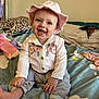 baby, child, smiling, hat, pink, shirt, embroidered, pants, striped, barefoot, blanket, cloud_pattern, pillow, leopard_print, clothes, bed, indoor, happy, sitting, person