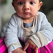 Avyaan joined the competition — help win amazing prizes! baby, child, face, eyes, hands, clothing, pink, zebra, pattern, portrait, indoor, cozy, cute, expression, sitting, person, infant, soft_focus, warm, young
