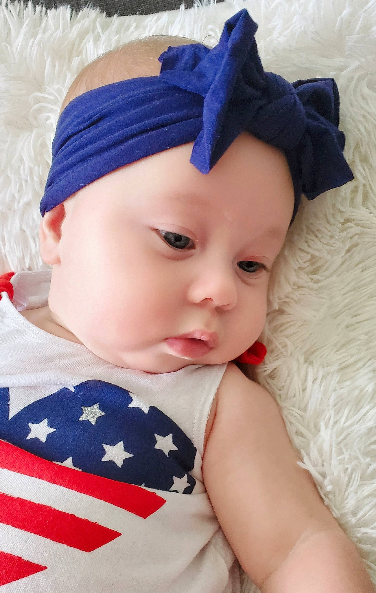 Bella is registered to the contest to win money with this photo: baby, baby_toddler_clothing, blue, cap, chin, clothing, eye, eyelash, face, flag_of_the_united_states, happy, hat, headgear, headwear, iris, lip, person, skin, sleeve, textile