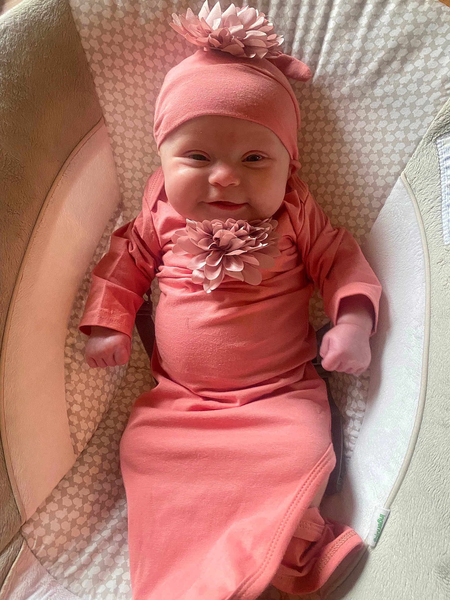 Ariella joined the competition — help win amazing prizes! baby, infant, pink_clothing, headband, flower_accessory, smile, cushion, seat, cozy, child, cute, portrait, indoors, soft_lighting, comfortable, young_child, baby_girl, adorable, sleeping_bag, hands
