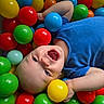 toddler, child, ball_pit, colorful_balls, blue_shirt, happy, laughing, play, indoor, plastic_balls, young_child, smiling, fun, cute, face, head, skin, blue_eyes, casual_clothing, joy