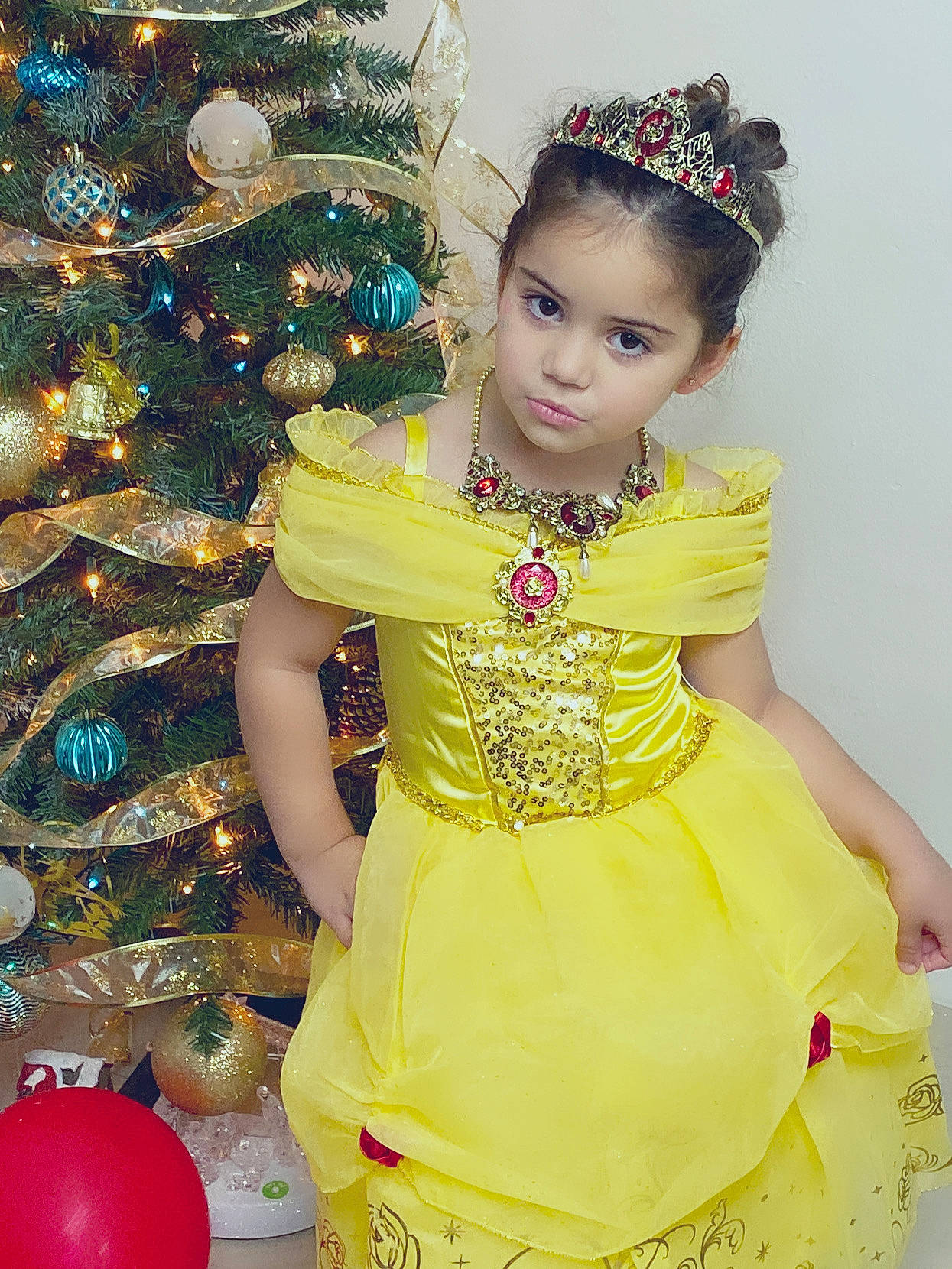 Princess is registered to the contest to win money with this photo: child, child_model, christmas, christmas_decoration, christmas_tree, costume, dancer, dress, event, fashion_accessory, fashion_design, hair_accessory, happy, headpiece, interior_design, person, smile, toddler, tradition, yellow