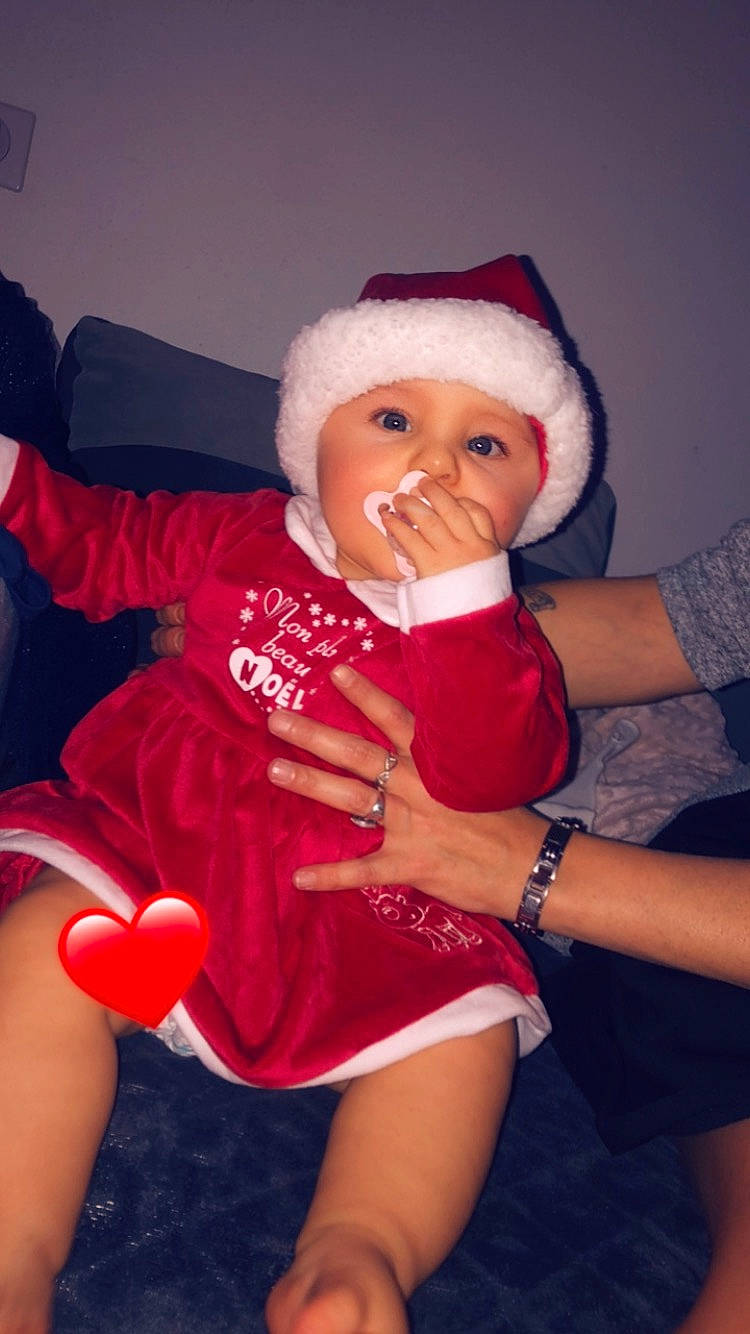 Selena participe au concours pour gagner de l'argent avec cette photo : baby, baby_toddler_clothing, cap, finger, flash_photography, fun, happy, headwear, human_body, knee, lap, lip, mouth, muscle, person, pink, santa_claus, skin, sleeve, smile