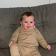 Leïya participe au concours pour gagner de l'argent avec cette photo : baby, infant, child, couch, sofa, knitwear, beige_clothing, shoes, smile, happy, indoor, person, seated, cute, face, young_child, cozy, home, portrait, casual
