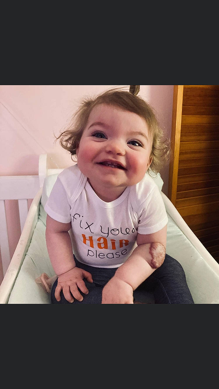 Charlie is registered to the contest to win money with this photo: arm, baby, baby_toddler_clothing, cheek, chin, cool, eye, eyebrow, finger, flash_photography, hand, happy, iris, joy, lip, mouth, nose, person, skin, sleeve