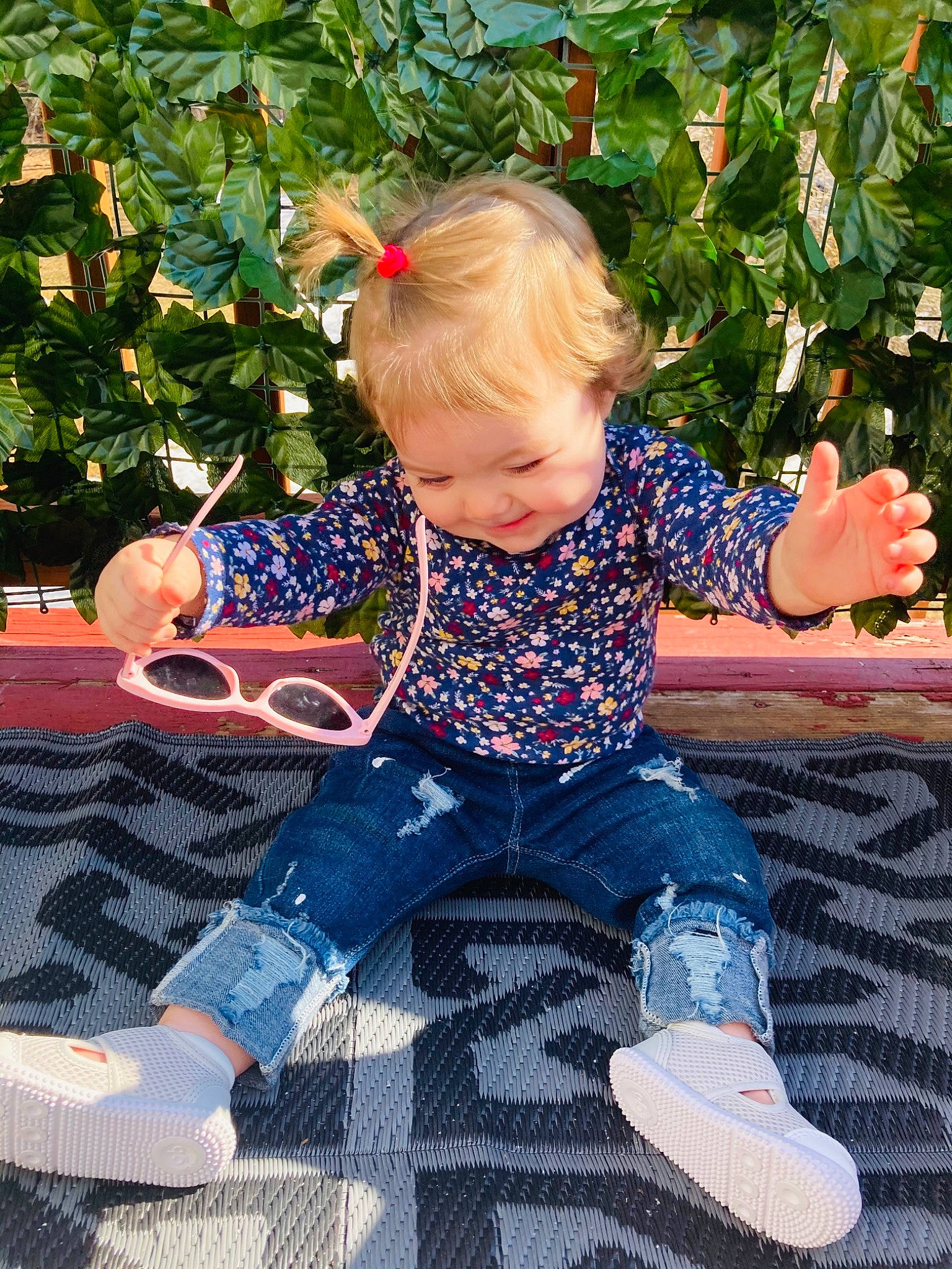 Charlie is registered to the contest to win money with this photo: baby_toddler_clothing, child, electric_blue, fun, grass, happy, jeans, leg, leisure, pattern, people_in_nature, person, plant, recreation, shoe, sitting, sleeve, smile, sneakers, t_shirt