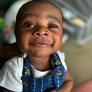 Tylin joined the competition — help win amazing prizes! baby, smile, close_up, face, child, infant, blue_outfit, white_shirt, button, happy, cute, portrait, indoors, person, skin, head, eyes, expression, young, baby_clothing