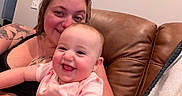 Siena joined the competition — help win amazing prizes! baby, infant, adult, smiling, happy, portrait, couch, leather, indoors, home, cuddling, family, pink_clothing, tattoo, earring, seated, close_up, face, photography, joy