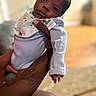 Shiloh joined the competition — help win amazing prizes! newborn, baby, infant, child, portrait, face, eyes_open, serious_expression, onesie, bib, blanket, sleeve, adult_arm, tattoo, holding, indoor, home, soft_lighting, shallow_depth_of_field, close_up