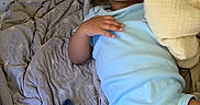 Noah joined the competition — help win amazing prizes! baby, infant, child, portrait, lying_down, curious, open_mouth, dark_hair, onesie, blue_clothing, blanket, star_pattern, plush_toy, pacifier, crib, bedding, indoor, close_up, relaxed, family_photo
