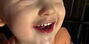 Tatum is registered to the contest to win money with this photo: child, toddler, smile, face, orange_shirt, happy, teeth, closeup, expression, indoor, person, young_child, holding, blue_object, casual_clothing, cute, portrait, skin, eyelashes, mouth