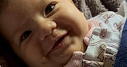 Kaylani joined the competition — help win amazing prizes! apparel, baby, blanket, child, close_up, clothing, cozy, cute, expression, face, happy, indoors, infant, joyful, portrait, smiling, soft_light, texture, warmth, young