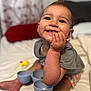 Hadleigh is registered to the contest to win money with this photo: toddler, child, smiling, happy, bed, blanket, toy, indoor, closeup, face, hand, casual_clothing, skin, person, cute, expression, playtime, infant, home, relaxed