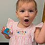 Hadleigh joined the competition — help win amazing prizes! toddler, child, pink_dress, striped_clothing, bow, toy_block, surprised_expression, hand, embroidery, indoor, carpet, face, person, cute, small_child, young_child, curly_hair, portrait, skin, eyes