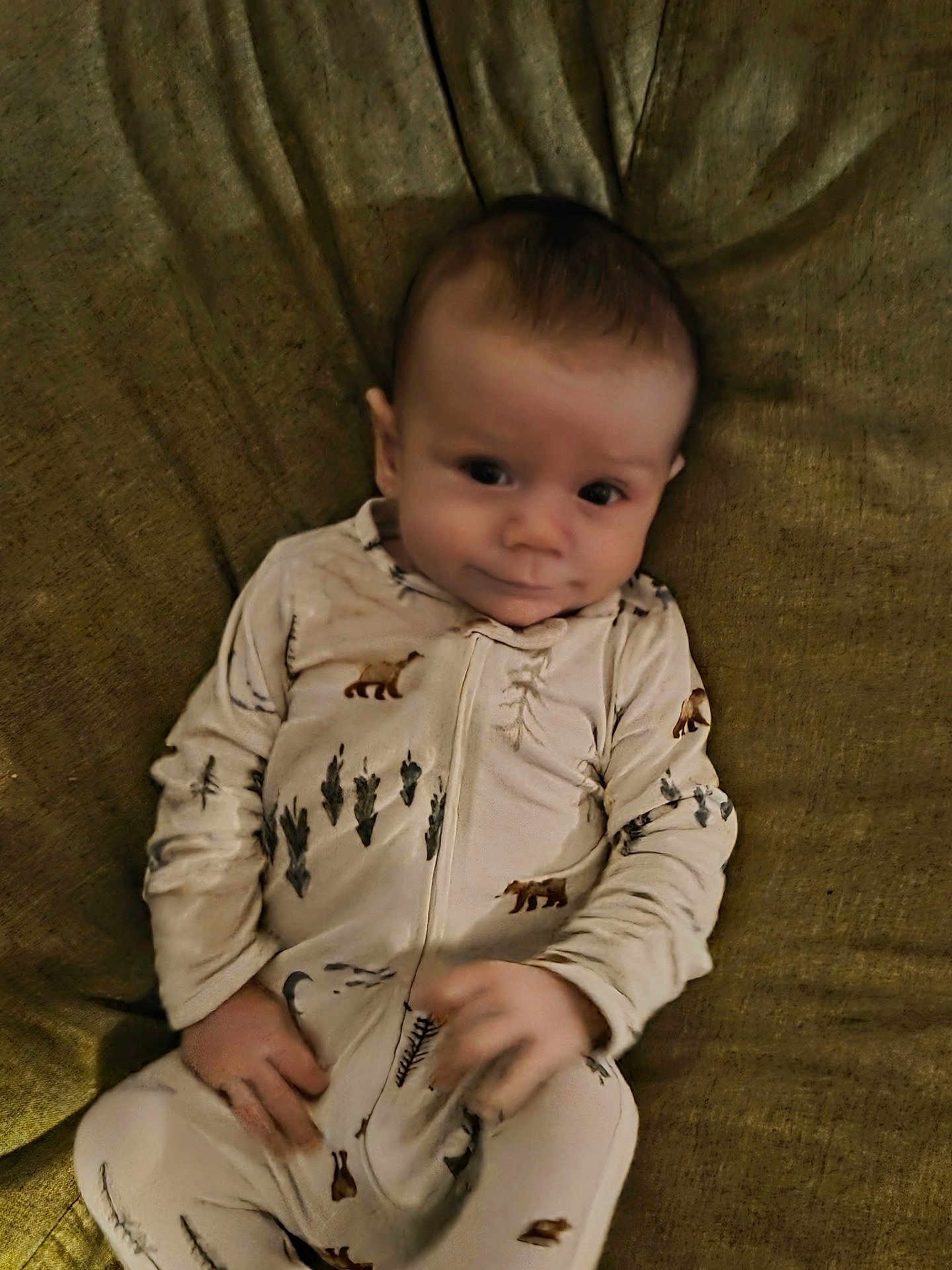 Otto joined the competition — help win amazing prizes! baby, infant, onesie, clothing, animal_print, bear, tree, couch, fabric, texture, person, child, smile, face, hand, portrait, indoor, cute, lying_down, young