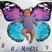 Amelia joined the competition — help win amazing prizes! antenna, baby, blanket, blue, butterfly_wings, child, colorful, cute, expression, floor, headband, infant, lying_down, months_marker, numbers, pattern, portrait, purple, purple_onesie, white