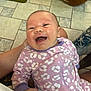 arm, baby, babywear, child, cute, floor_tiles, hand, happy, holding, human, indoor, infant, laughing, newborn, onesie, patterned_clothing, person, portrait, purple_clothing, smiling