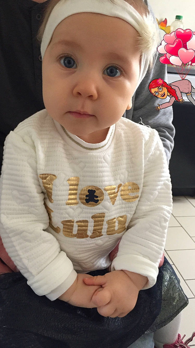 Leilani a rejoint le concours — aidez-le/la à gagner de superbes lots ! baby, baby_toddler_clothing, beauty, cheek, child, eye, face, head, lip, nose, outerwear, person, product, sitting, skin, sleeve, smile, t_shirt, toddler