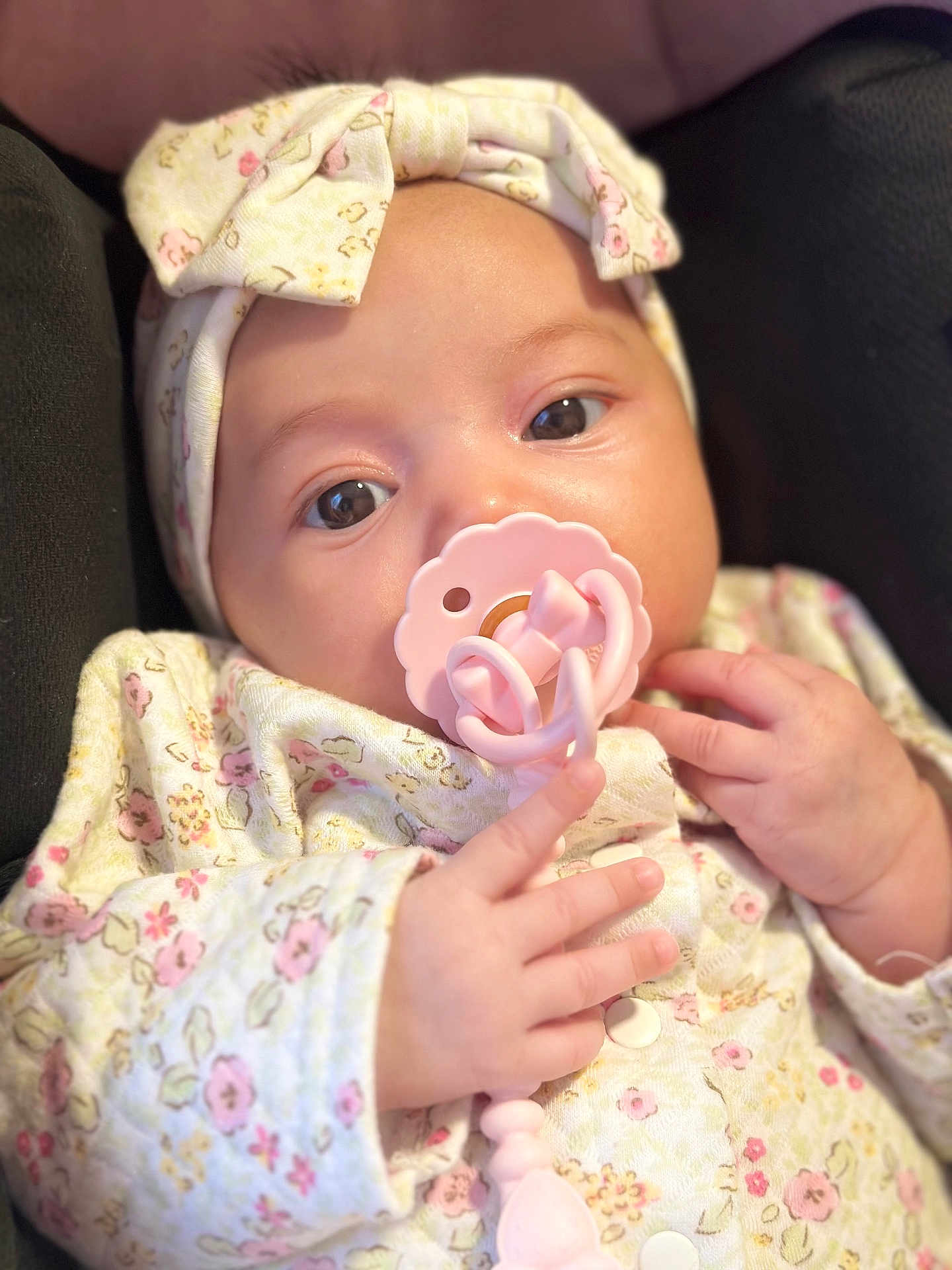 Clara is registered to the contest to win money with this photo: baby, infant, pacifier, headband, floral, clothing, cute, closeup, hand, soft, portrait, newborn, child, pink, pattern, sleepwear, babywear, face, expression, cozy