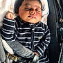 baby, sleeping, car_seat, blanket, striped_clothing, infant, child, peaceful, cute, safety_harness, black_and_white, soft_texture, indoors, portrait, resting, young_child, head, hand, foot, cozy