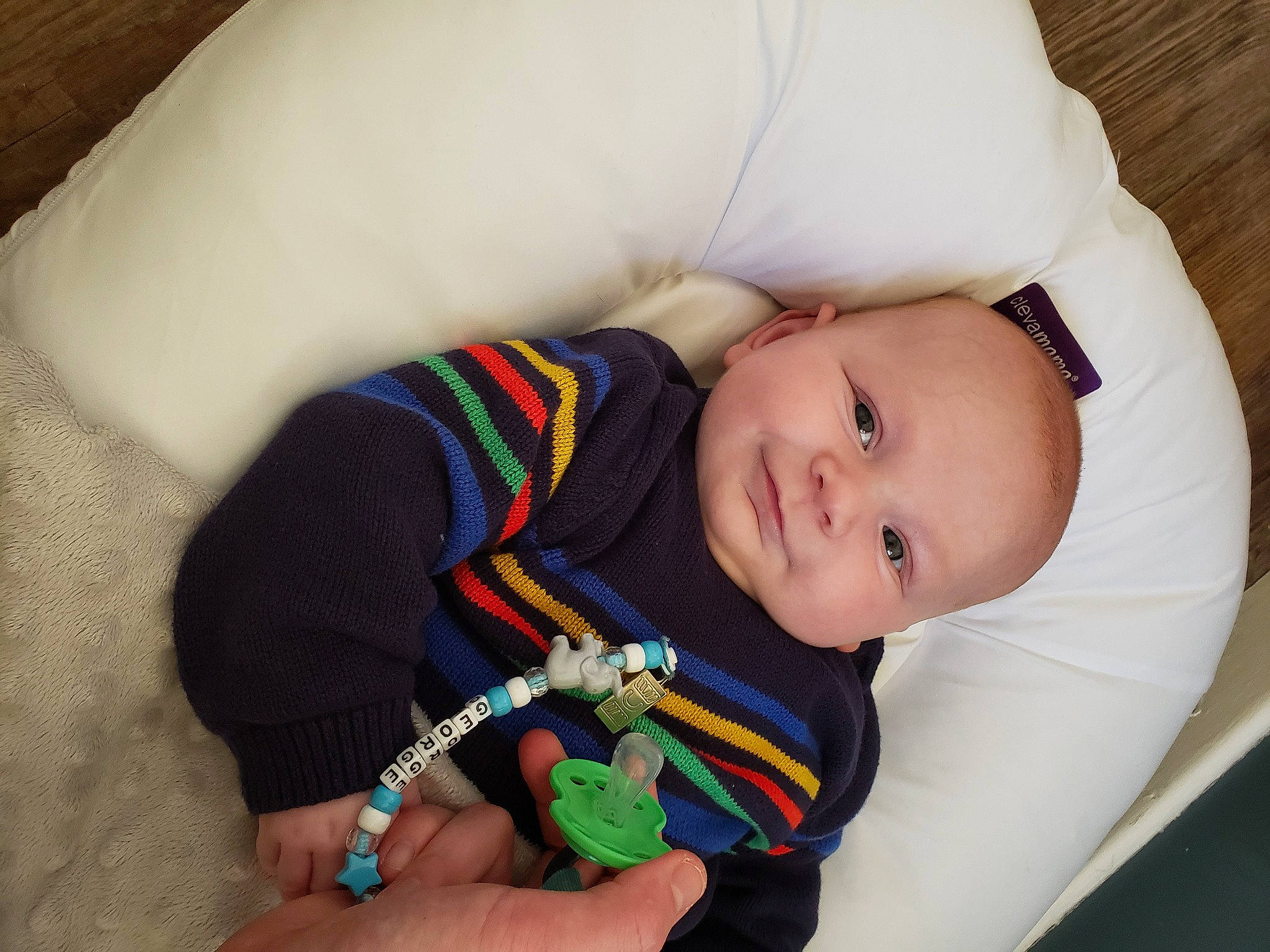 George is registered to the contest to win money with this photo: arm, baby, baby_products, baby_sleeping, baby_toddler_clothing, cheek, child, comfort, eye, hand, happy, joy, linens, nail, pattern, person, sitting, skin, sleeve, smile