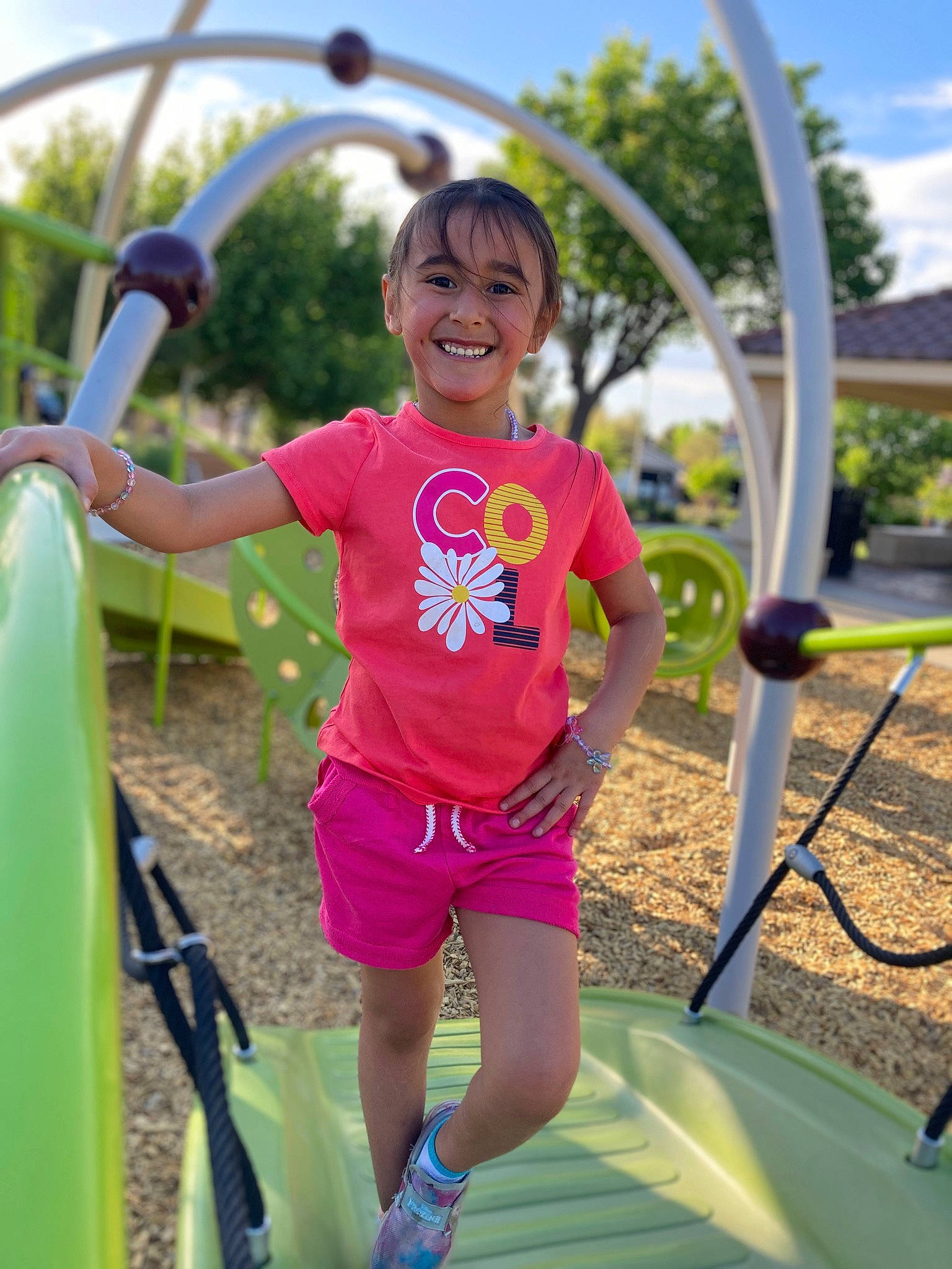 Elaina Kauhi is registered to the contest to win money with this photo: child, city, cloud, fun, happy, joy, leisure, magenta, outdoor_play_equipment, outdoor_recreation, people_in_nature, person, pink, play, playground, recreation, shade, shorts, sky, smile