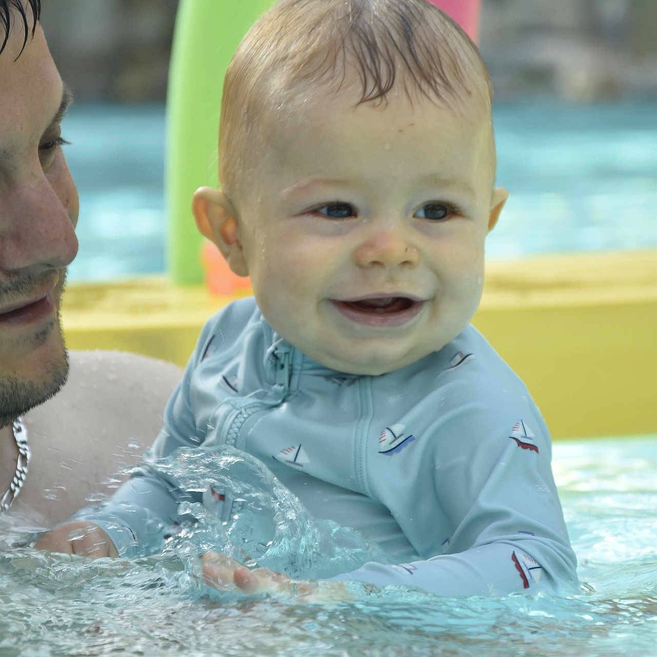 Maël a rejoint le concours — aidez-le/la à gagner de superbes lots ! adult, baby, child, closeup, colorful, face, fun, happy, outdoor, parent, playful, sailboat_pattern, smiling, splashing, summer, support, swim_shirt, swimming_pool, toys, water