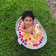 Thiago joined the competition — help win amazing prizes! child, toddler, milk_bath, orange_slices, strawberries, outdoor, grass, curly_hair, bathtub, food, fruit, water, skin, summer, nature, relaxation, playful, healthy, fresh, cute