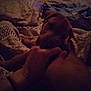 Chief is registered to the contest to win money with this photo: dog, pet, brown_dog, hand, human_hand, bed, blanket, pillow, sheets, bedroom, indoors, low_light, night, cozy, sleeping, tv, furniture, comfort, animal, blanket_pattern