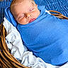 newborn, baby, sleeping, infant, portrait, blue_blanket, swaddled, basket, wicker, white_fabric, peaceful, indoors, close_up, face, closed_eyes, resting, cozy, photography, bedding, wooden_floor