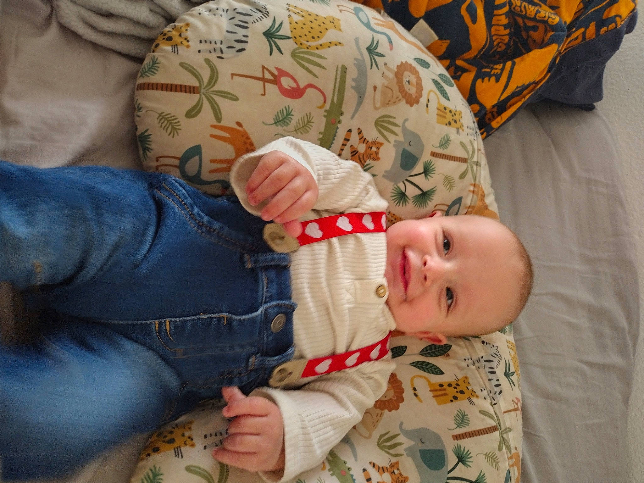 Theos is registered to the contest to win money with this photo: baby, baby_toddler_clothing, cheek, child, comfort, finger, gesture, joy, lap, linens, nail, pattern, person, room, sitting, skin, sleeve, smile, textile, toddler