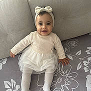 Emily participe au concours pour gagner de l'argent avec cette photo : baby, bow, child, clothing, couch, cute, fabric, floor, happy, headband, indoor, infant, pattern, person, portrait, sitting, smiling, sweater, tutu, white_tights